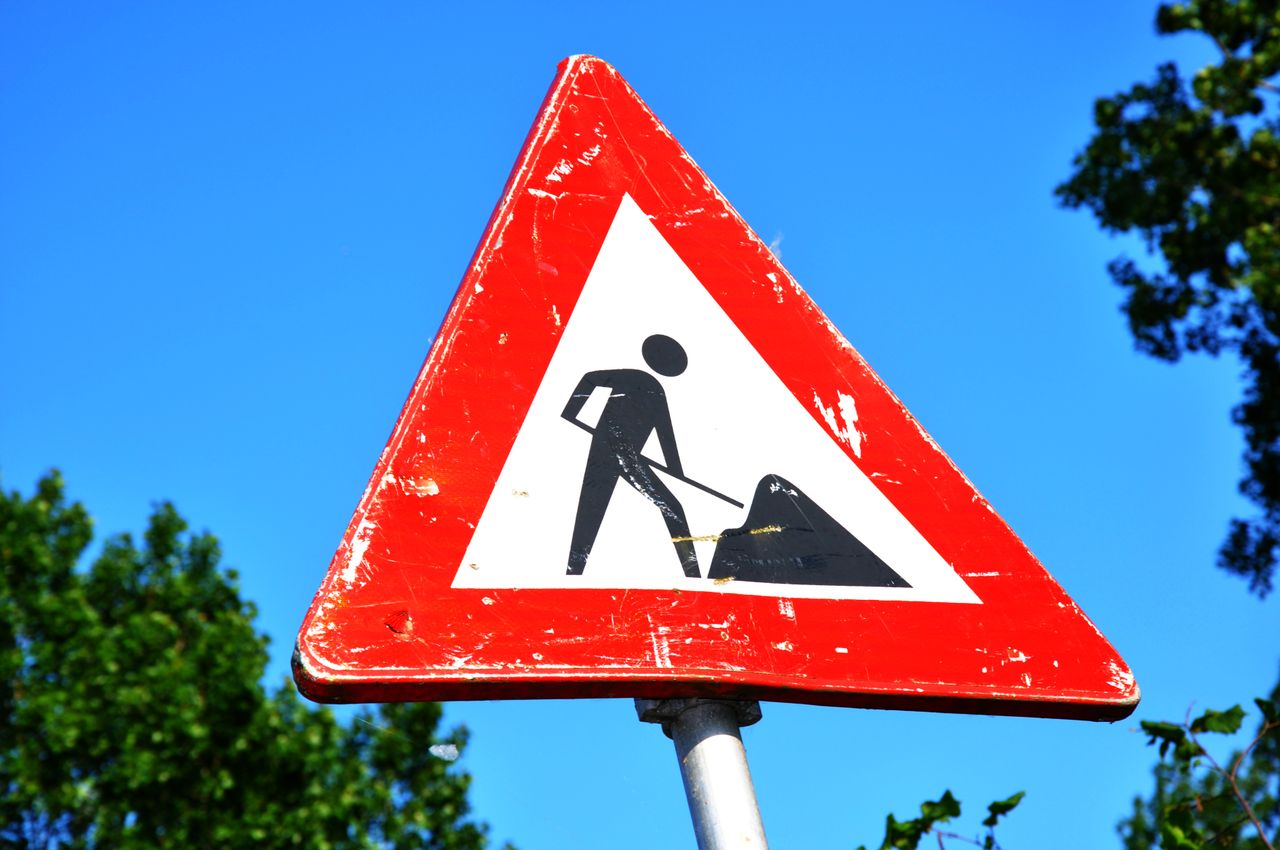 Verkeersbord voor werken in uitvoering tegen een blauwe lucht